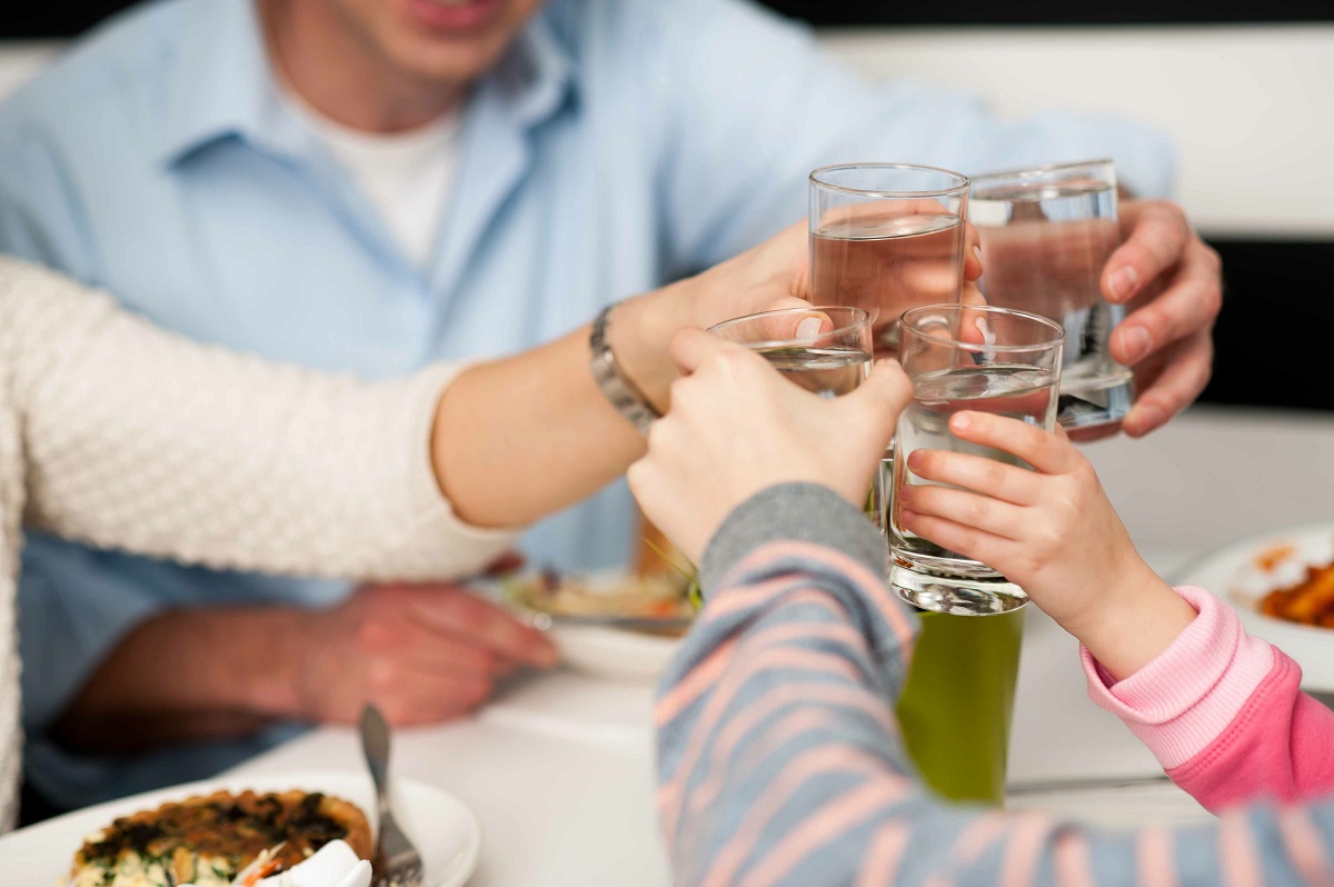 family toasting water glasses - inline water filter